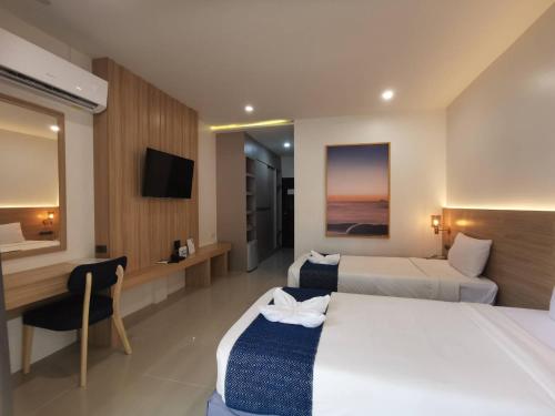 a hotel room with two beds and a desk at Nana Beach Hotel & Resort in Pathiu