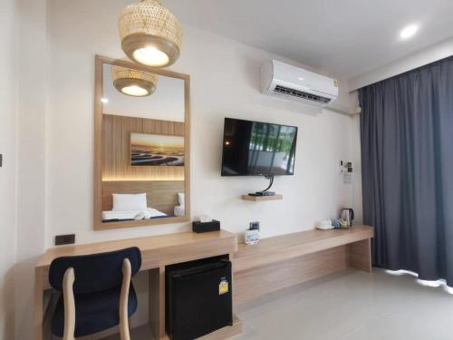 a room with a desk with a tv and a mirror at Nana Beach Hotel & Resort in Pathiu