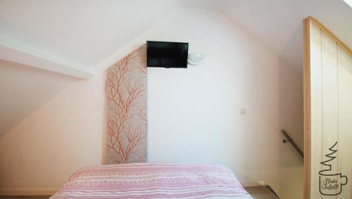a bedroom with a bed and a tv on the wall at Studio Juliette in Stavelot