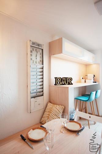 a table with plates and glasses and a bar sign at Studio Juliette in Stavelot
