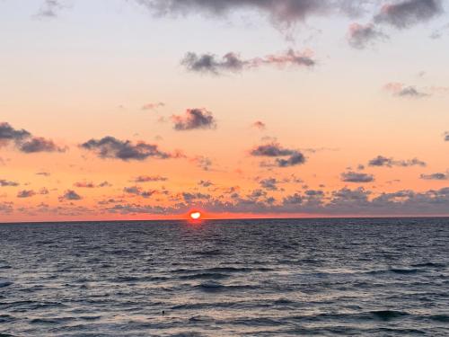 a sunset over the ocean with the sun setting at Beautiful view in Nida