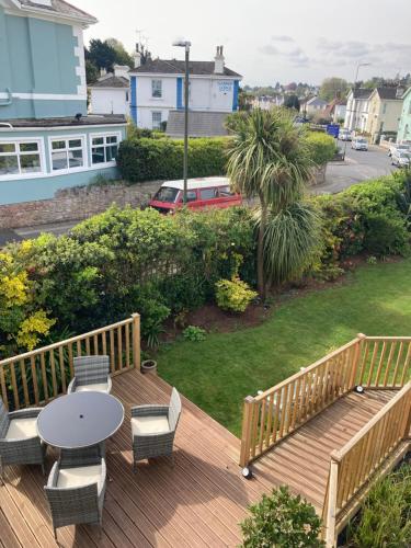 a wooden deck with a table and chairs on a yard at Bentley Lodge in Torquay
