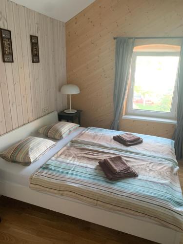 a bedroom with a bed with two towels on it at Beautiful view in Nida