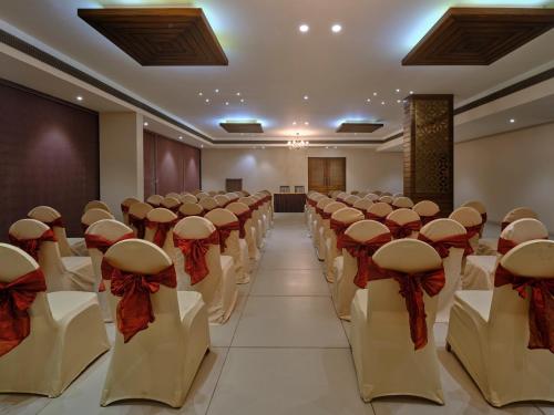a conference room with rows of chairs with bows at Pride Biznotel Manjusar Vadodara Near Sokhda Lake in Vadodara