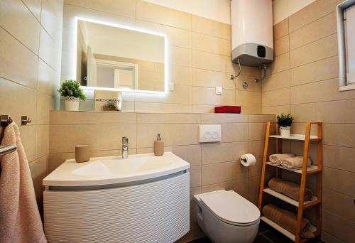 a bathroom with a sink and a toilet and a mirror at Sea Front Apartments Ivana in Rogoznica
