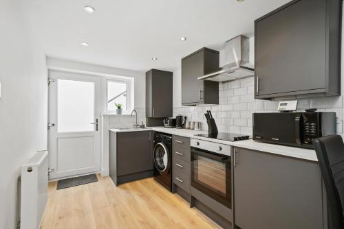 una cucina con lavatrice e asciugatrice di Luxnightzz - Stylish Boutique 1 Bed Apartment a Gravesend