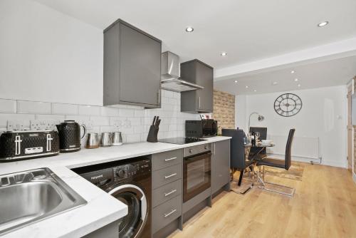 una cocina con fregadero y lavavajillas. en Luxnightzz - Stylish Boutique 1 Bed Apartment, en Gravesend