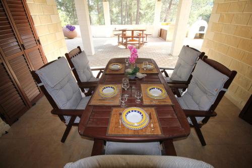 einem Holztisch mit Platten und Blumen darauf in der Unterkunft House of Roses in Limassol