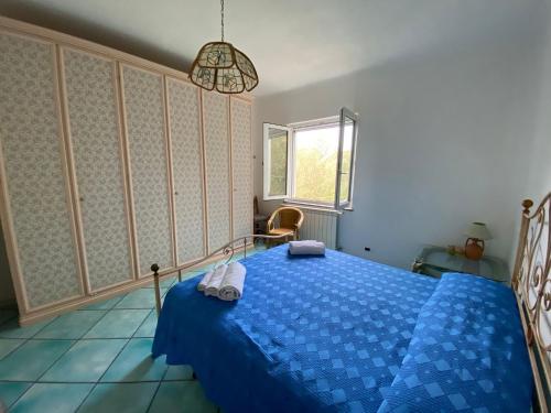 a bedroom with a blue bed and a window at Le Dimore di Zaro - Green Paradise in Forio d'Ischia