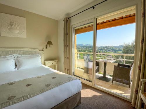 - une chambre avec un lit et un balcon avec vue dans l'établissement Hotel Marc-Hely, à La Colle-sur-Loup