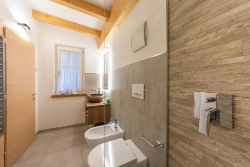 a bathroom with a toilet and a sink at Attico Faloria Luxury in Moena