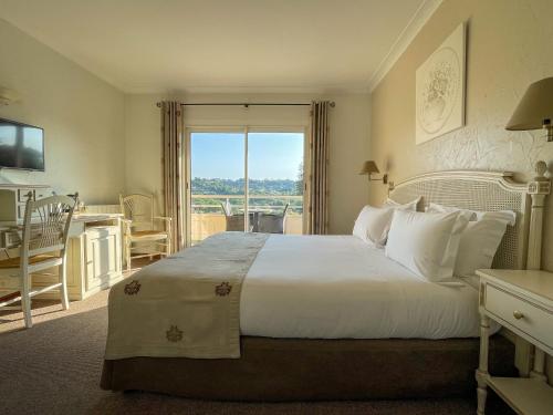 a bedroom with a large white bed with a window at Hotel Marc-Hely in La Colle-sur-Loup