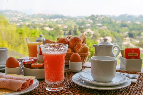 a table with a breakfast of juice eggs and bread at Hotel Marc-Hely in La Colle-sur-Loup