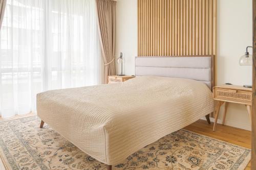 a bedroom with a large bed and a window at SimSim Apartamentai in Šventoji