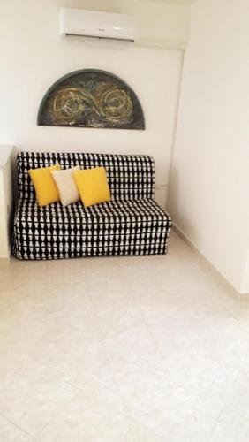 a black and white couch with two yellow pillows at In Vacanza a Gaeta - Libera Stella in Gaeta
