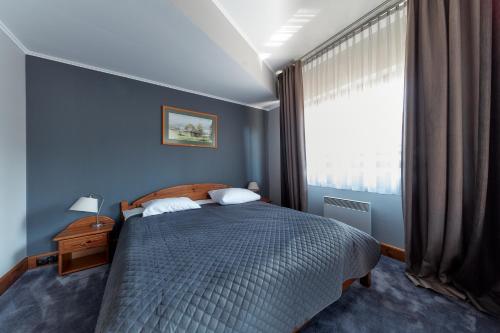 a bedroom with a bed and a window at Hotel Skalny in Zakopane