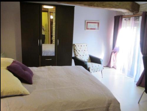 a bedroom with a bed and a chair at Chambres, Table d'Hôtes et Gites Les Mesanges in Saint-Jean-de-Sauves