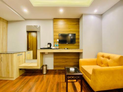 a living room with a couch and a television at The Eleganza in Jhājra