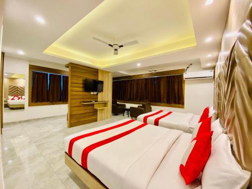 a bedroom with two beds and a flat screen tv at The Eleganza in Jhājra
