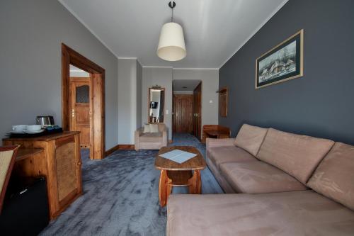 a living room with a couch and a table at Hotel Skalny in Zakopane