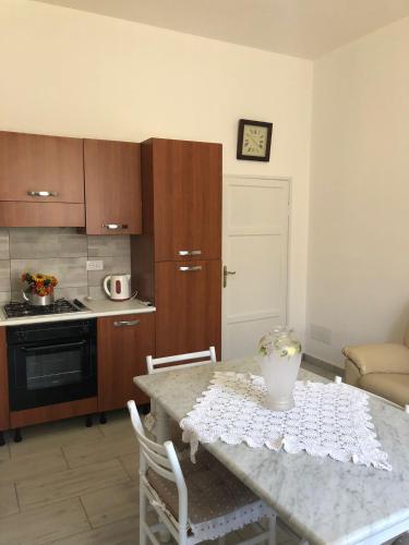 uma cozinha com uma mesa e uma cozinha com uma mesa e cadeiras em casaMare em Venturina Terme