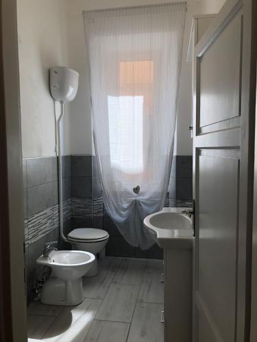 uma casa de banho com WC, 2 lavatórios e uma janela em casaMare em Venturina Terme