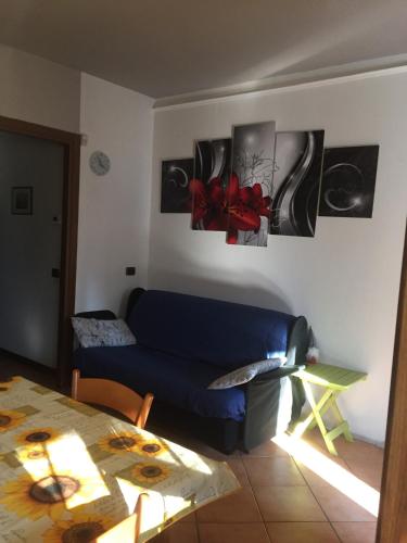 a living room with a blue couch and pictures on the wall at Casa Grazia in Magreglio