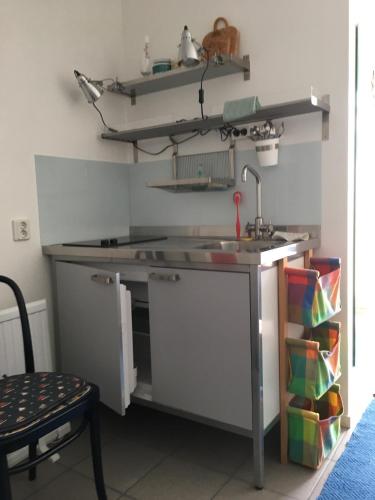 a kitchen with a sink and a counter with a shelf at Hos Mona-Lisa in Grundsund