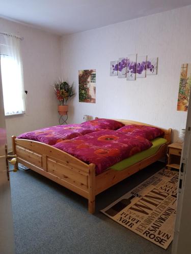 a bedroom with a large wooden bed with purple sheets at Weingut Helmut Barzen in Zell an der Mosel