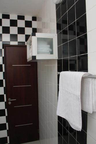 a bathroom with a black and white checkered wall at Résidence Hôtelière Lauria in Lomé