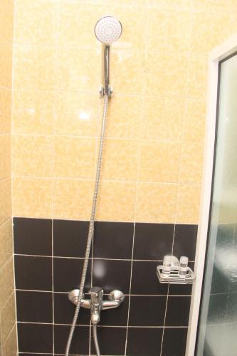 a shower with a shower head in a bathroom at Résidence Hôtelière Lauria in Lomé