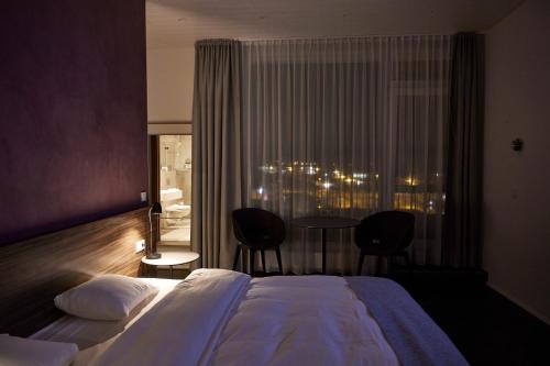 a hotel room with a bed and a chair at B59 Hotel in Borgarnes