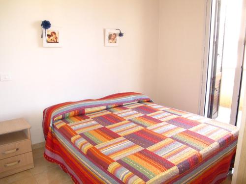 una camera da letto con un letto con una trapunta colorata di Otranto Vacanza Facile - Via delle Memorie a Otranto