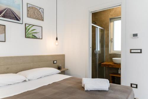 - une chambre avec un lit et un lavabo dans l'établissement MandorloCarrubo's suite, à Ostuni
