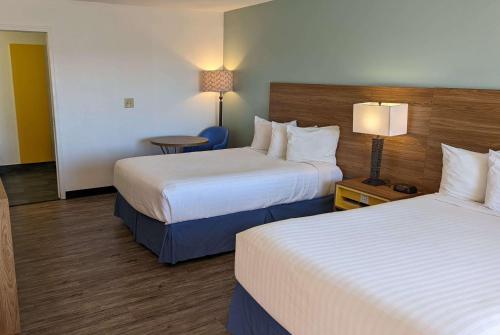 a hotel room with two beds and a table at Days Inn by Wyndham Lake Havasu in Lake Havasu City