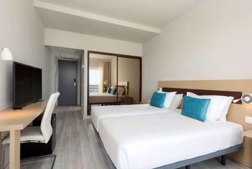 a hotel room with a bed and a desk at TRYP by Wyndham Lisboa Caparica Mar in Costa da Caparica