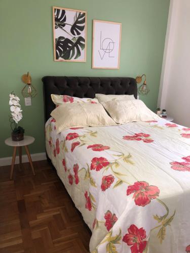 um quarto com uma cama com colcha floral em Apartamento Centro Histórico de Petrópolis 200Mbps de internet em Petrópolis