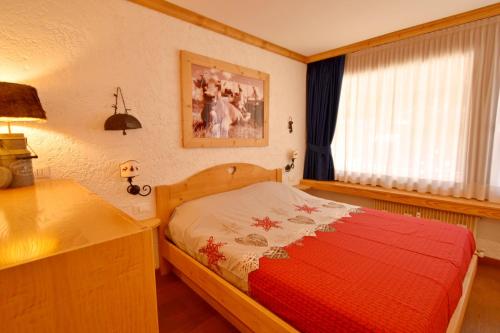a bedroom with a bed and a table and a window at Casa MARGHERITA Rainalter in Madonna di Campiglio