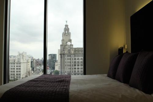 a bedroom with a bed with a view of a building at Liver View Apartments in Liverpool