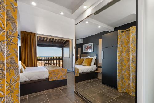 1 dormitorio con 2 camas y balcón en VIEW port venus naturiste, en Cap d'Agde