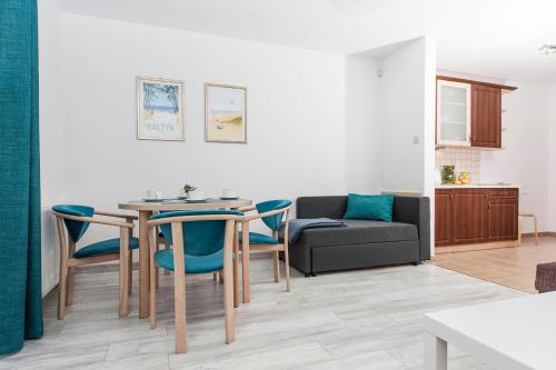 a living room with a table and chairs and a couch at Jaśmin in Rowy