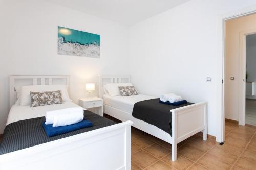 a bedroom with two beds and a mirror at Luxury Villa Perla in Caleta De Fuste