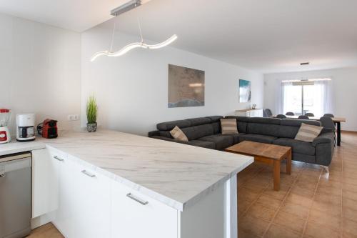 a white kitchen and living room with a couch at Luxury Villa Perla in Caleta De Fuste