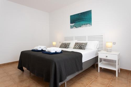 a bedroom with a bed with two towels on it at Luxury Villa Perla in Caleta De Fuste