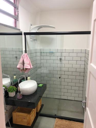 a bathroom with a sink and a glass shower at Apartamento Centro Histórico de Petrópolis 200Mbps de internet in Petrópolis