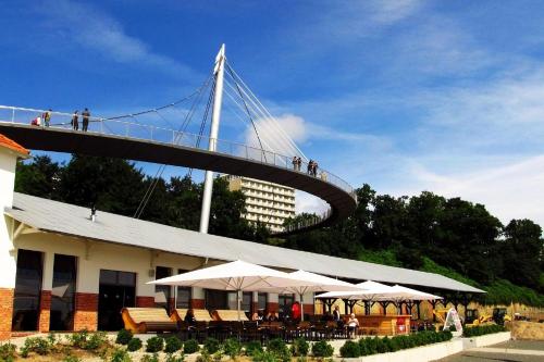 a suspension bridge over a building with tables and umbrellas at Ferienwohnung Seebrise in Sassnitz