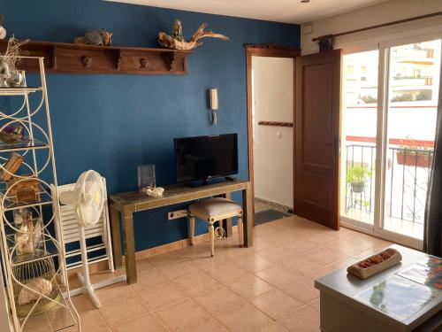 a living room with a tv and a desk with a computer at ApartaUnMomento y Disfruta!! in Estepona