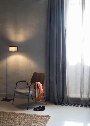 a chair sitting in a room with a window at Antica Dimora Le Misure in Cervia