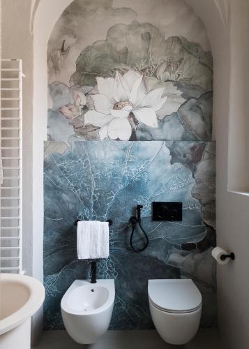 a bathroom with a mural of flowers on the wall at Antica Dimora Le Misure in Cervia