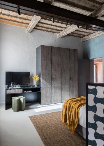 a bedroom with a bed and a tv in a room at Antica Dimora Le Misure in Cervia